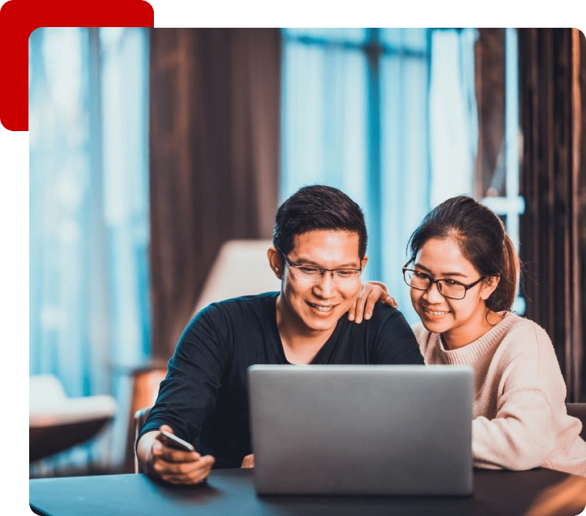 A man and woman looking at a laptop.